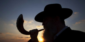 A Jew blows a shofar, Ram's horn, while others pray as they perform Tasklikh, a Rosh Hashanah ritual for casting sins upon the waters, in front of the Mediterranean sea, in Ashdod, Israel, Thursday, Sept. 29, 2011.  Tasklikh is when Jews symbolically throw their sins into moving water during the New Year holiday of Rosh Hashana. (AP Photo/Ariel Schalit)